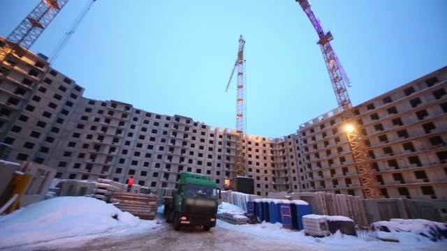 Building works at construction site in winter evening.