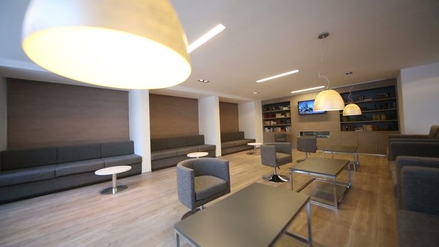 Rest-room with sofas, tv and tables at modern business center 