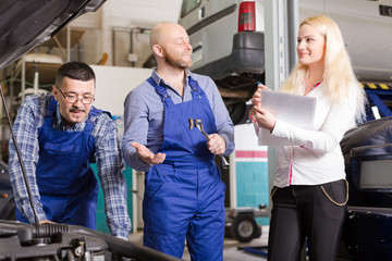 Obraz premium Woman and two auto mechanics