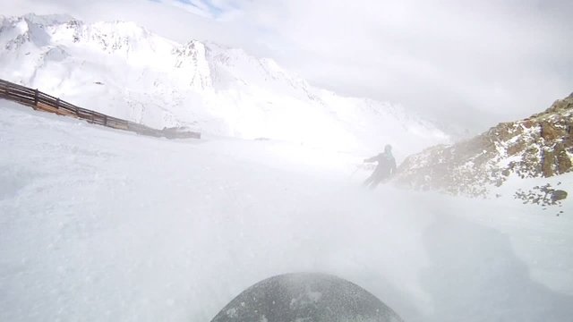 Snowboarder very quickly moves down on ski route against ridges