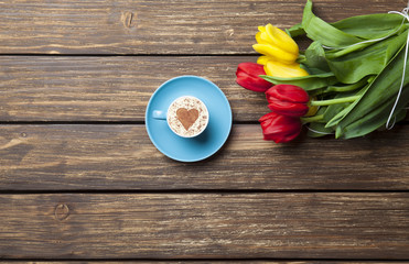 cappuccino with heart shape and bouquet of tulips