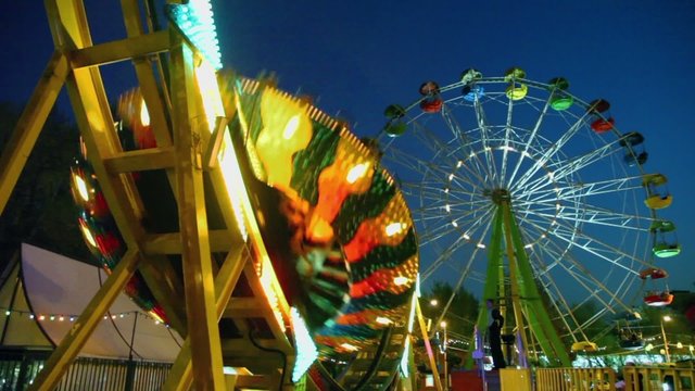 People ride on round circling attraction Disko which sways