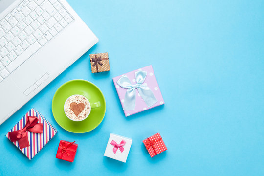 computer with gift bxes and cappuccino