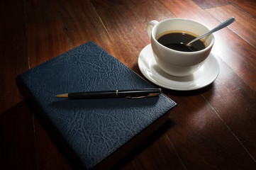 Coffee cup with book and pen.