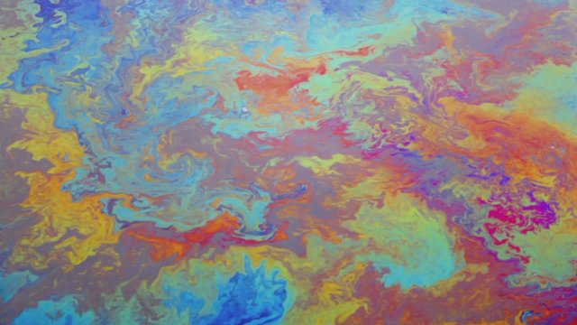Oil pollution spreads by water surface of river at day