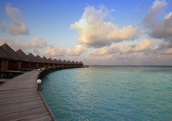 Obraz premium Houses over the sea at sunrise. Maldives