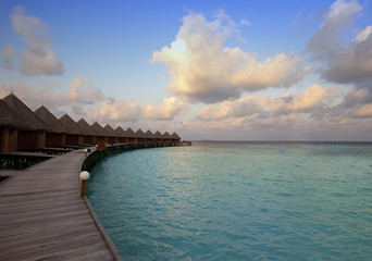 Houses over the sea at sunrise. Maldives