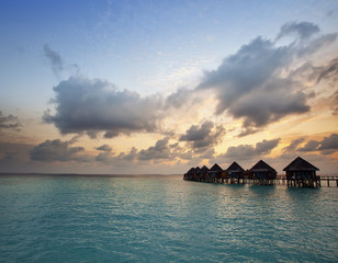 Houses over the sea at sunrise. Maldives