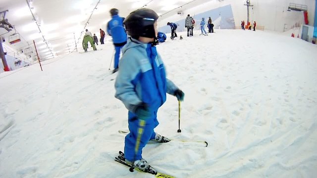 Boy stands on mountain top in ski complex