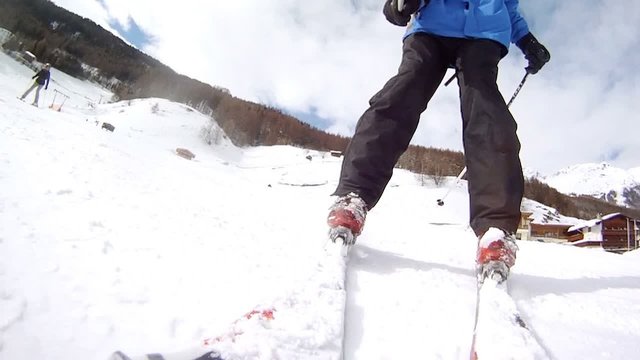 Man goes slowly on skis on white pure snow from mountain