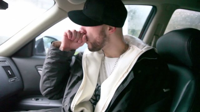 Adult rapper reads rap when sits in car on street