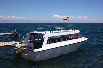 Tour boat at wooden jetty at Lake Titicaca in Bolivia