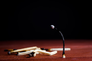 one burned match standing and many burned matches lying