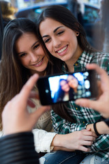 Three young woman using mobile phone at cafe shop.