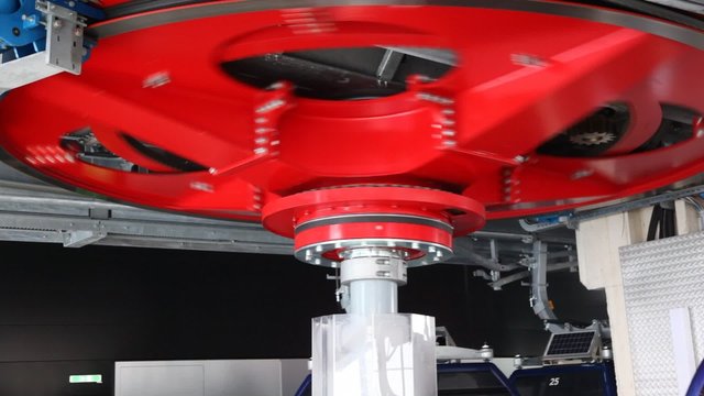 Big red screw turns mechanism with cable car cabins