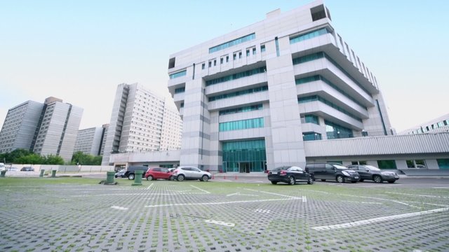 Cars parked near modern office building, (shown in motion)