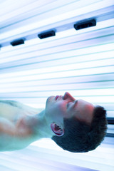 Young man relaxing during a tanning session in a solarium