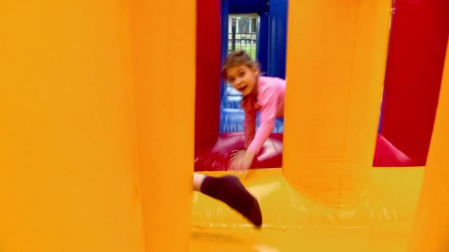 Two kids boy and little girl crawls at inflatable playground at sunny summer day