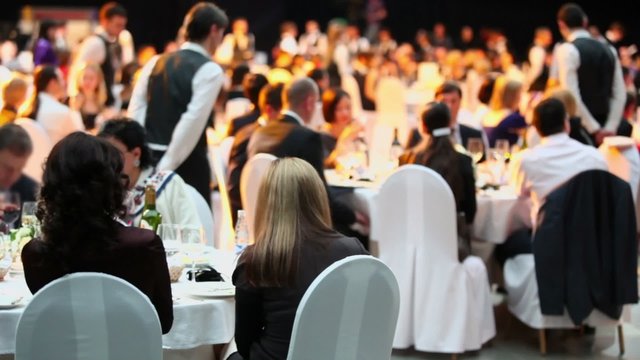 People sit at tables during Ceremony of rewarding of winners