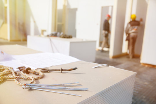 Screws On Plasterboard Panels With Workers