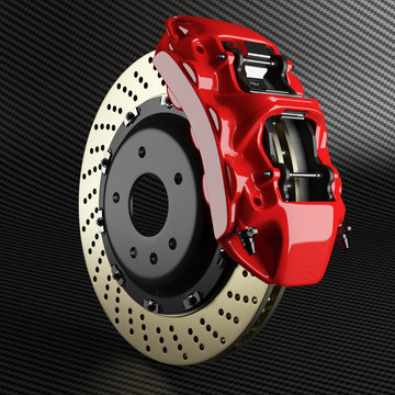 Automobile brake disk and red caliper on carbon background