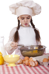 Little girl in a white apron breaks near the plate with eggs