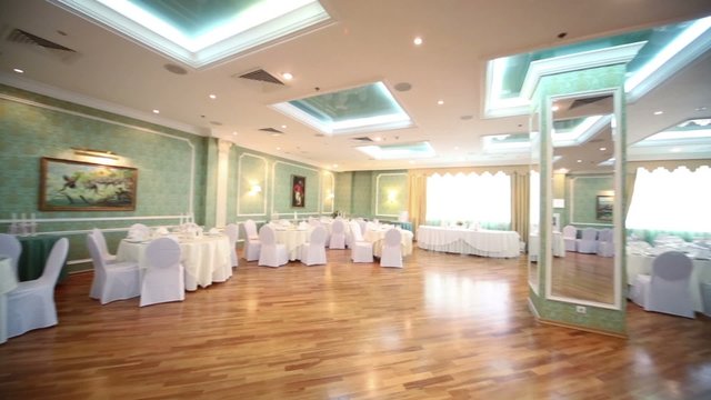 restaurant hall with tables decorated for a wedding celebration
