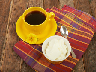 Coffee and yogurt, breakfast on the table wooden background