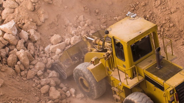 top view excavator loading crushed rock on dumper truck