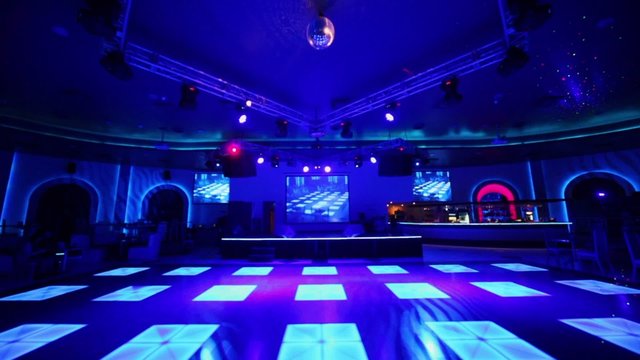 Few people in club with dance floor near stage and bar