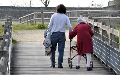 Personne âgée en déambulateur avec accompagnant