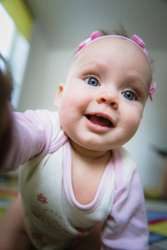 Adorable baby girl taking picture of herself, selfie.