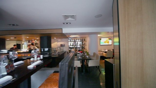 Eastern restaurant with bartenders and working tv on wall