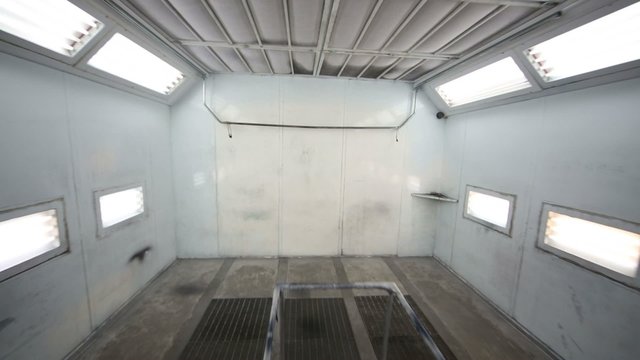 Empty paint-spraying booth with grey metal walls for cars