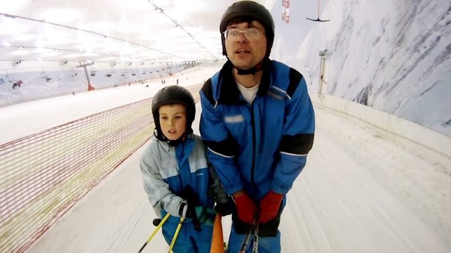 Father with son rise on skilift in ski complex