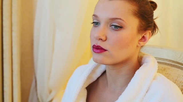 portrait beautiful young girl in bathrobe with red pomade