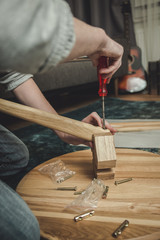 Ein junger Mann baut einen Tisch zusammen