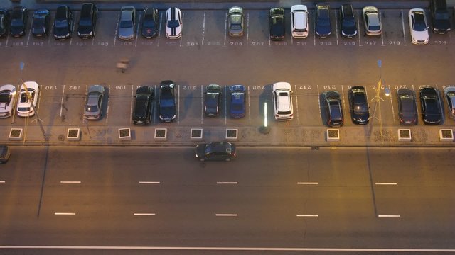 Aerial view of car traffic on street at night and parking lot