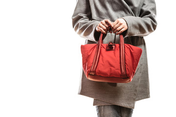 woman in gray coat holds red handbag