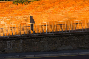 shadow of a person casted on a orange wall