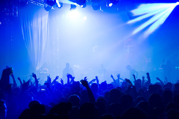 people at a concert raising hands