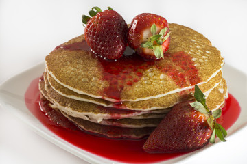 Pancakes with fresh strawberries and strawberry syrup.