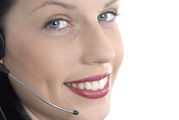 Attractive smiling female girl secretary or call center receptionist talking speaking microphone telephone headset eyes looking at camera white background photo
