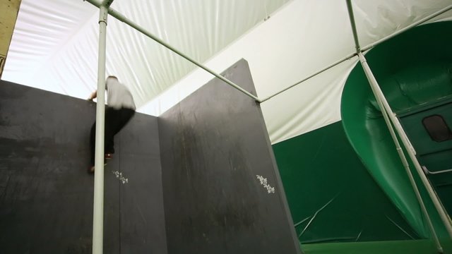 Agile boy jumping from the beam on wall at place for parkour training