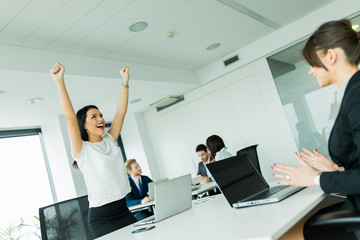 Businesswoman jumping from joy and raises hands