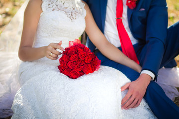 red bouquet on the bride's knees