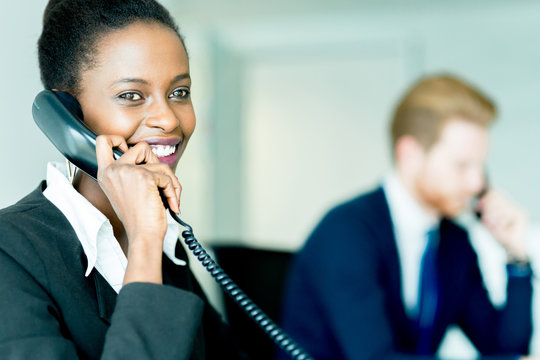 A beautiful, black, young woman working in a call center
