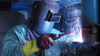 Industrial worker welding steel pipe flange