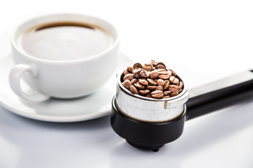 Portafilter with coffee beans and cup brewed espresso
