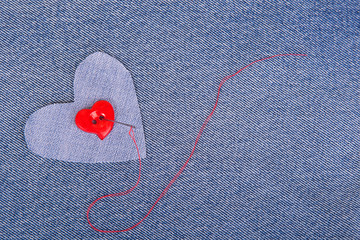 Red heart shaped button with needle and red thread